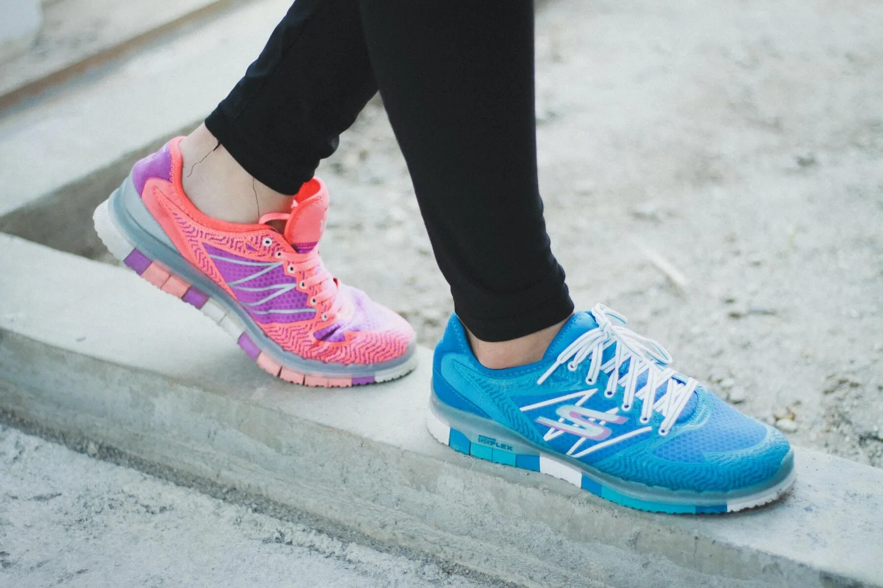 woman balancing on concrete curb with colored sneakers sketchers work-life balance in nursing